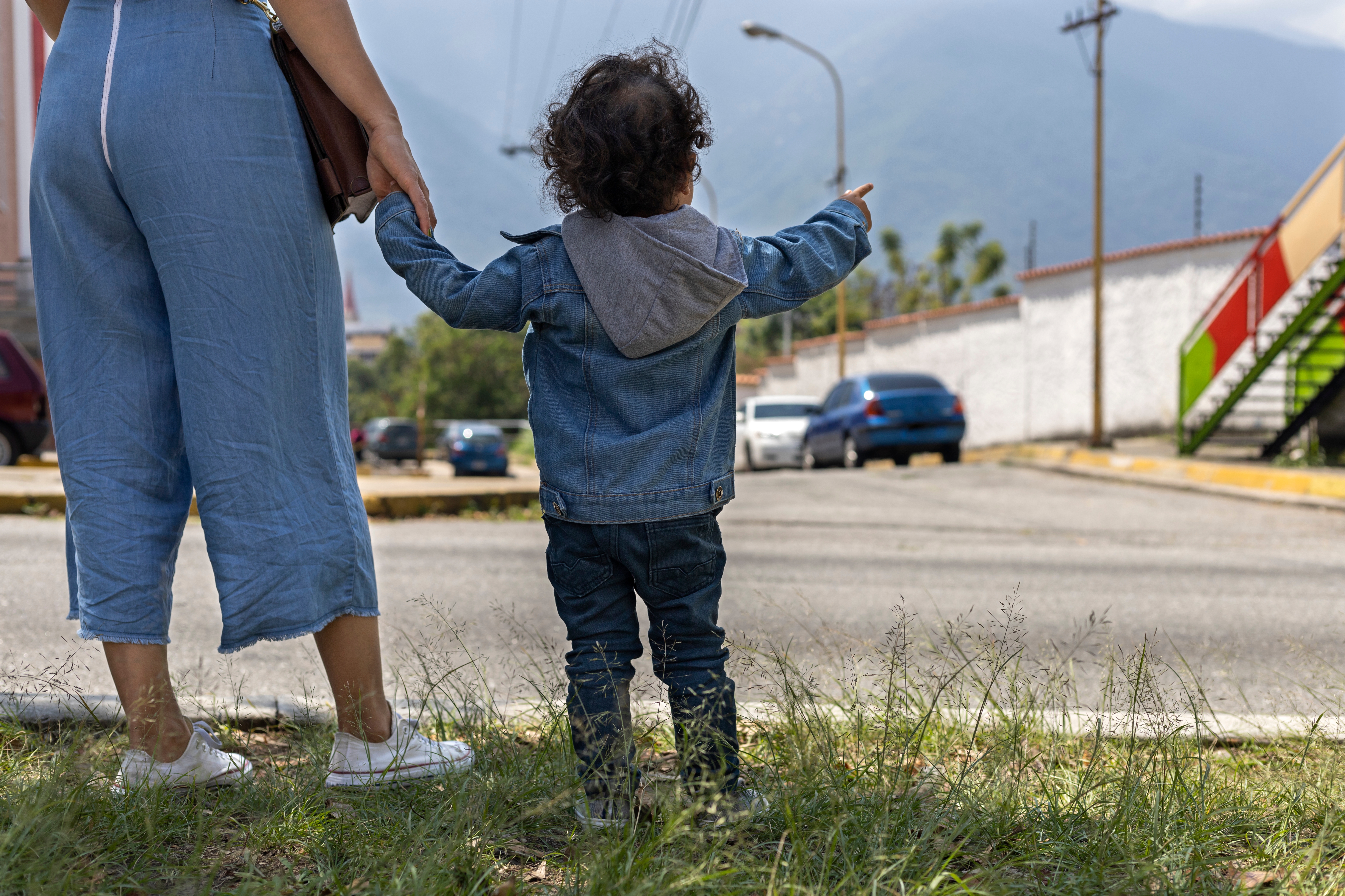 adult and toddler walking in urban area